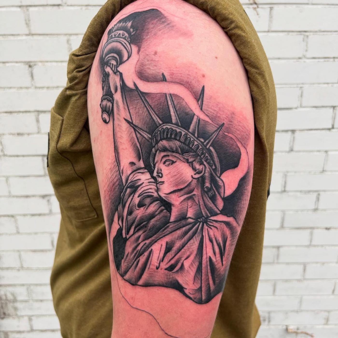 A black and gray Statue of Liberty shoulder tattoo