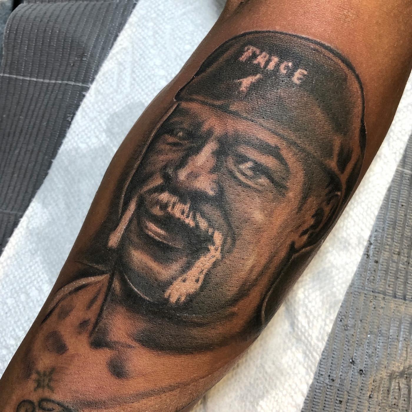 A black and gray portrait realism tattoo on a forearm